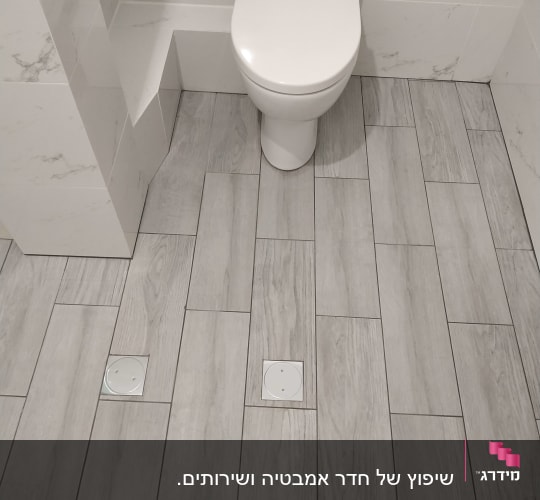 ריצוף חדש בחדר אמבטיה עם אריחים אפורים